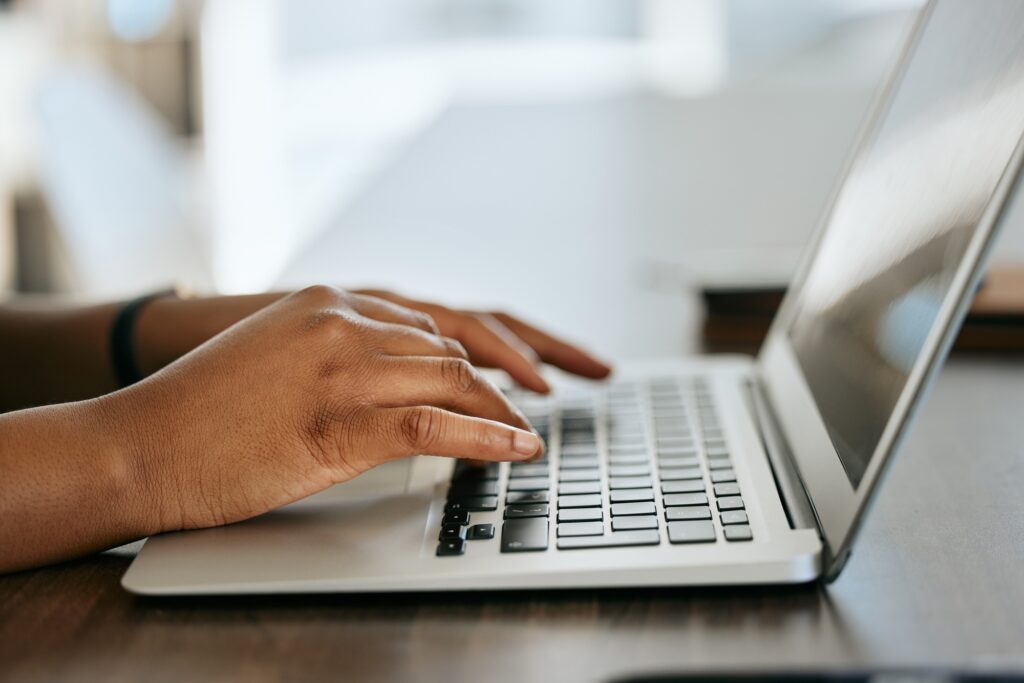 Laptop, hands typing and writer with research for website copywriting, newsletter and blog ideas or
